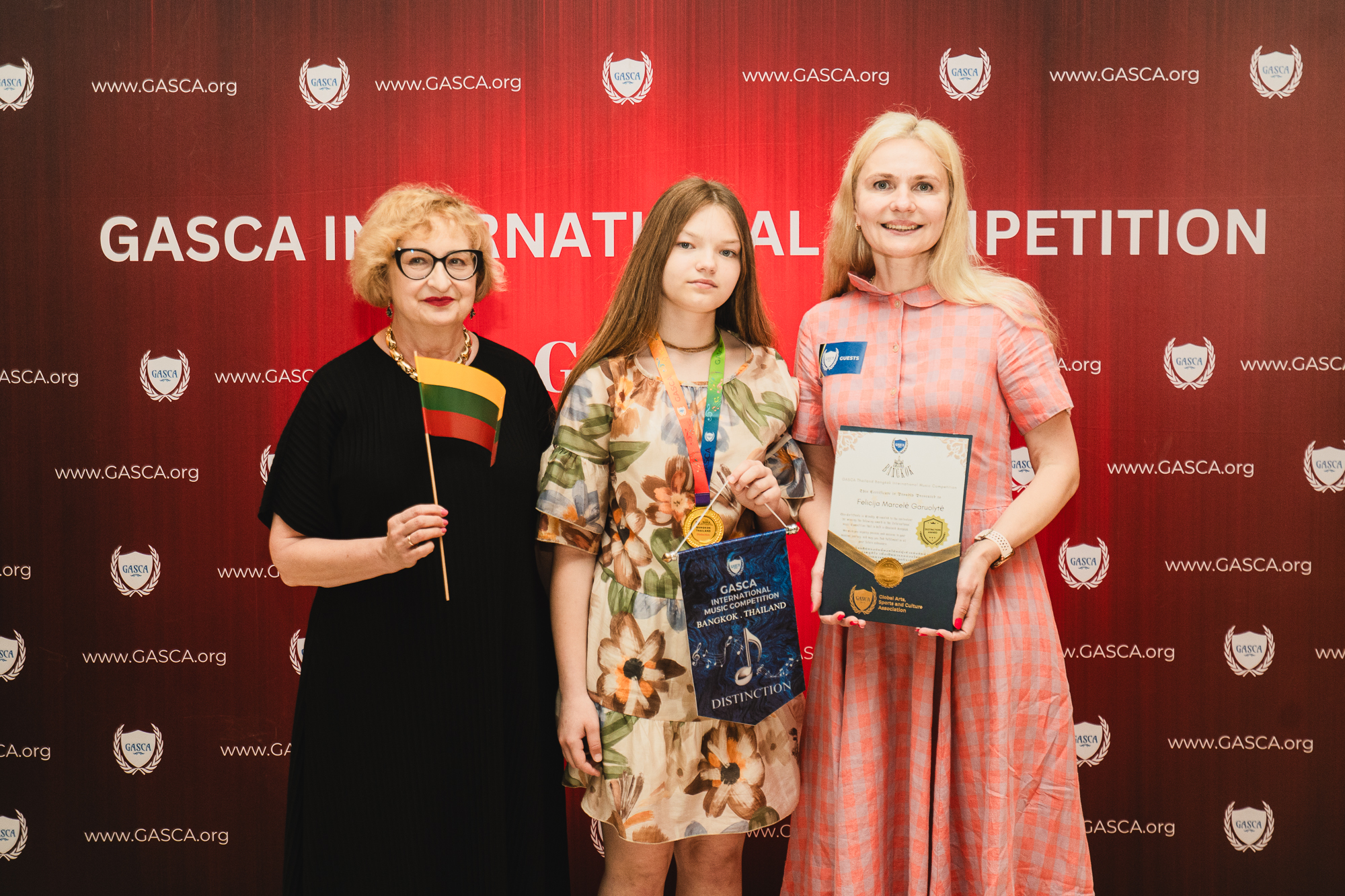 Participant with Lithuanian flag, medal and distinction certificate
