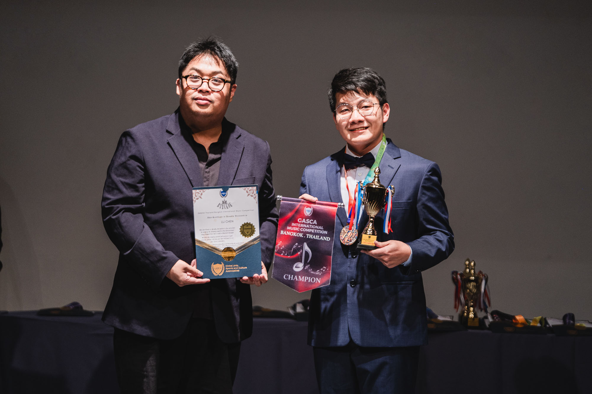 Award recipient with champion pennant, certificate, medal and trophy