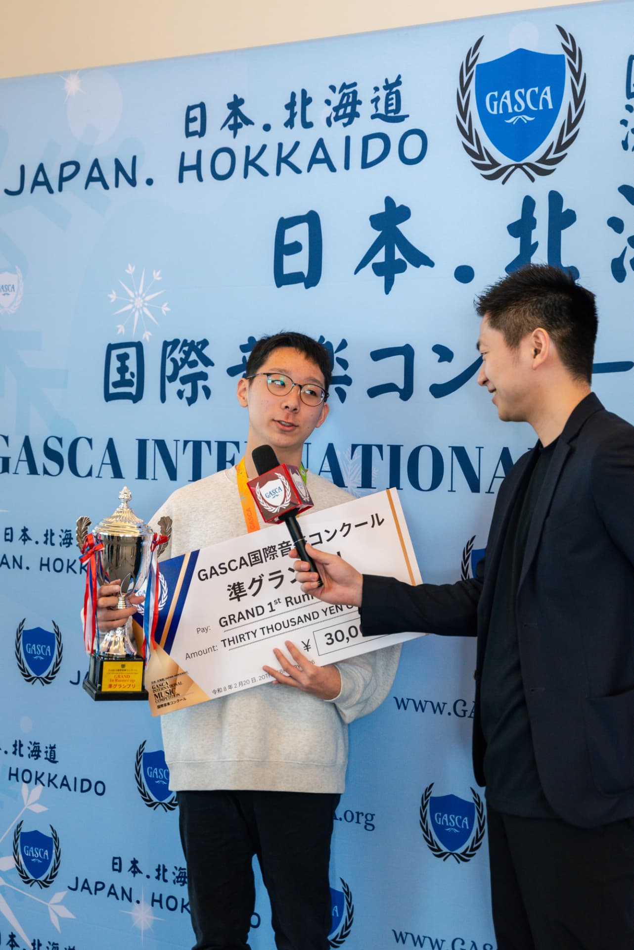 Hokkaido first runner-up speaking during a winner interview with trophy and cheque