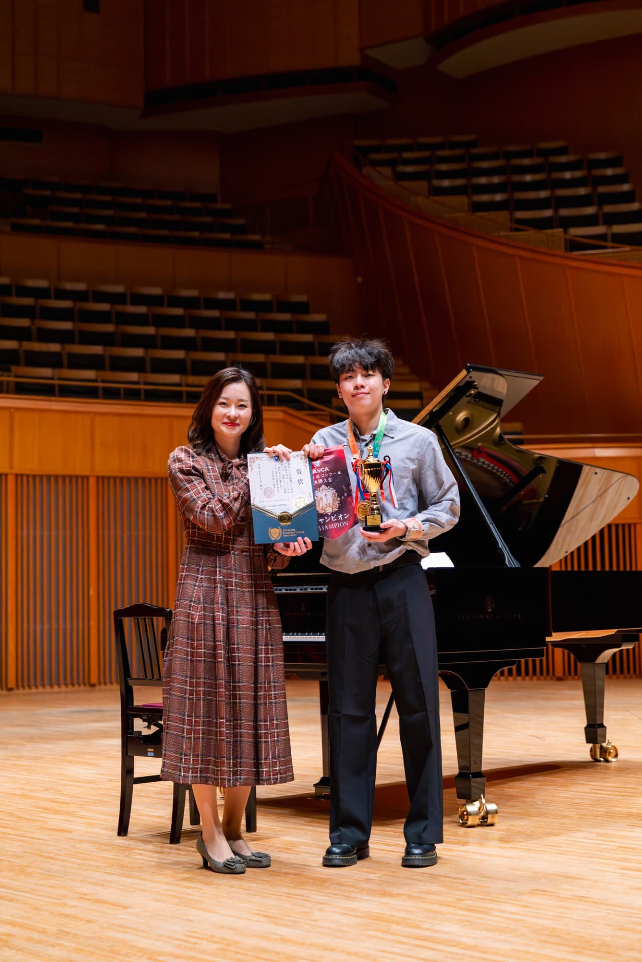 Champion receiving trophy, medal and certificate on stage